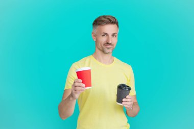 Sabah kahvesi vakti. Yaşam tarzı konsepti. Kafeinsiz içiyorum. Çay içen adam. Sıcak bir sabah, rahatla. Kahveci adamla kahve molası. Olgun bir adam mavi kahve fincanını seçer..