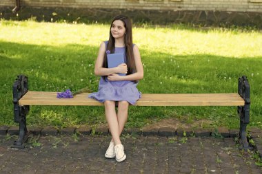 Neşeli kız rahatla, kitap park bankında, kopyalama alanı.