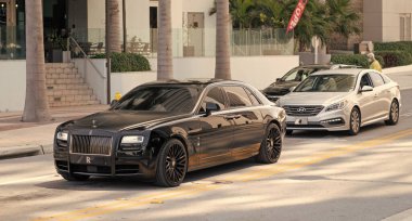 Miami Beach, Florida ABD - 15 Nisan 2021: Roll-Royce ve hyundai araçları yolda.
