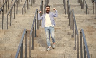 shouting bearded guy walk downstairs. full length of guy with beard. hipster guy outdoor at stairs.