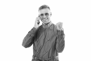 Mutlu gülümseyen başarılı iş adamı CEO 'su cep telefonuyla konuşuyor kazanan jest yapıyor resmi palto stüdyosunda, telefonda izole edilmiş..