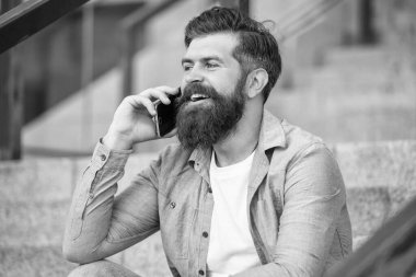 Kafkasyalı adamın dışarıda akıllı telefon görüşmesi var. Adamın dışarıda akıllı telefon görüşmesi var. Adamın sokakta akıllı telefonları var. Fotoğrafta akıllı telefon var..