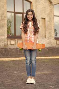 skateboarding of smiling teen girl in the street. photo of teen girl skateboarding. skateboarding of teen girl outdoor. skateboarding of teen girl outside.