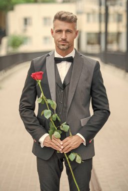 engagement date. tuxedo man celebrates engagement. man with rose present for engagement.