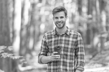 happy caucasian man with coffee wearing checkered shirt. photo of caucasian man with coffee in the forest. caucasian man with coffee outdoor. caucasian man hold coffee.