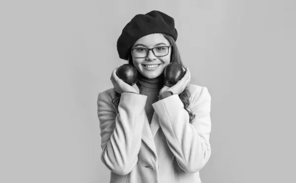 stock image happy teen girl with apple. photo of teen girl holding apple. teen girl with apple isolated on yellow background. teen girl hold apple in studio.