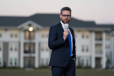 Emlakçı yeni bir ev teklif ediyor. Profesyonel iş adamı emlakçı. Paralı takım elbiseli başarılı bir emlakçı. Satılık ev. Emlak hizmetleri. İpotek konsepti. Emlakçı ücretleri.