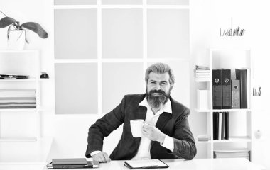 Yakışıklı patron ofiste oturup kahve içiyor. Sakallı hippi kıyafeti kahveyle rahatlıyor. İlham verici ve motive edici. Ofiste sabah kahvesi. Ofis hayatı. Kahve güzelmiş. Saygıdeğer CEO..