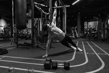 Spor sporcusu spor salonunda yan tahta egzersizi yapıyor. Beden eğitiminde yan tahta egzersizi. Spor ve spor. Spor salonundaki sporcunun kalas egzersizi.