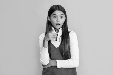 Sarı arka planda uzun saçlı hayret bir çocuk..