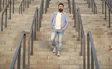 Sakallı adam aşağıda yürüyor. Sakallı bir adam. Merdivenlerde hippi bir adam var..