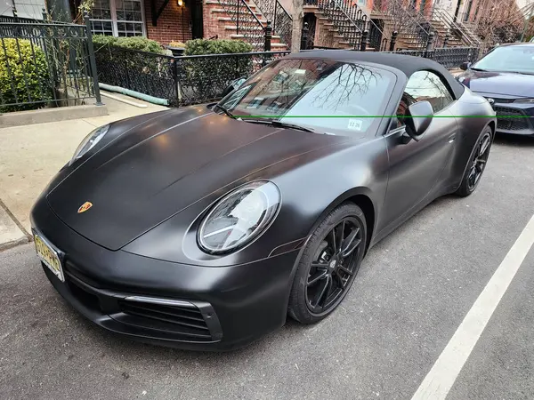 New York City, ABD - 10 Şubat 2024: Porsche 911 Carrera 4 s Cabriolet siyah araba, ön görüş.