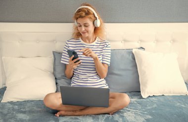 Telefonda gülümseyen kadın sohbeti. Evde telefonla konuşan bir kadın. Kulaklıklı kadının telefon görüşmesi..