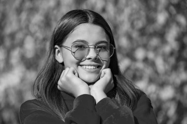 teen girl smile outdoor in autumn season wearing sunglasses.