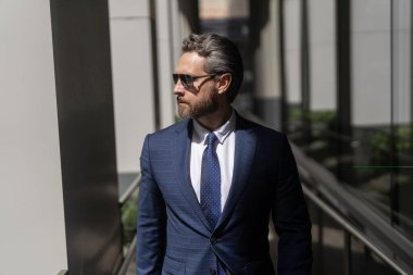 Yakışıklı CEO 'nun portresi. Başarılı bir gelecek vizyonu. Yeni fırsatlar. Ofis binasındaki iş adamı. Başarılı bir iş patronu. İş adamı kıyafeti. Modern cam ofisindeki iş adamı. Çalışma günü.