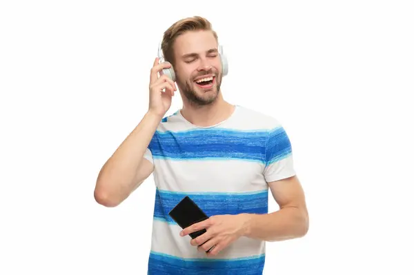 stock image Man with headphones using phone. Generation z guy use phone app for training music. Modern phone with wireless headphones isolated on white. Millennial man listening to music in headphones.