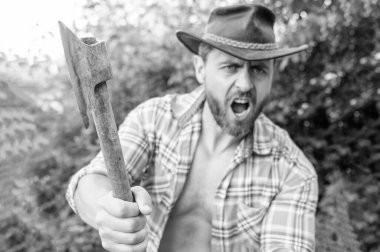 selective focus of angry lumberjack with axe. angry lumberjack with axe wearing checkered shirt. angry lumberjack with axe outdoor. photo of angry lumberjack with axe. clipart