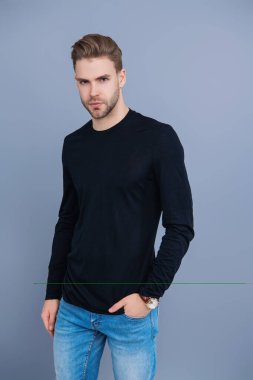 Erkeklerin güzelliği. Kendine güveni olan adam. Gündelik kazak giyen genç yakışıklı bir adam. Tıraşsız adam Griler 'de izole edilmiş. Şık saç kesimi olan bir adamın portresi. Milenyum karizmatik modeli. Duygusal Manyetizma.