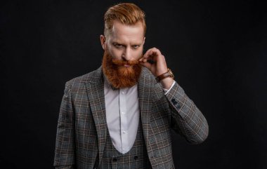 Resmi smokinli şık sakallı adam siyah giyinmiş..