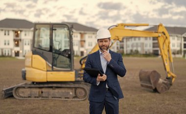 Gülümseyen inşaat müfettişi mühendis açık havada mimarlık yapıyor. İnşaat müfettişinin fotoğrafı. İnşaat müfettişi mimarlığı. İnşaat müfettişi mimarlığı