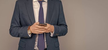 Stüdyoda erkek telefonu konuşması. Telefonu olan genç bir iş adamı. İş iletişimi. Gri yolda izole bir şekilde telefonda sohbet eden sıradan bir iş adamı. Telefon kullanan bir iş adamı. Boşluk afişini kopyala.