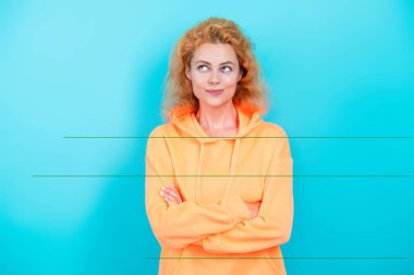 Mavi üzerine kapüşonlu giyen kadın. Moda modeli. Şık kapüşonlu kızıl saçlı kız. Sıradan kapüşonlu, şık, beyaz bir kadın. Modayla ilgilenen kız modaya uygun ve parlak görünüyor. Sportif kıyafet..