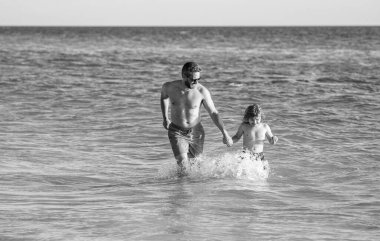 Baba oğul yaz tatilinin tadını çıkarıyor baba ve çocuk deniz sahilinde..