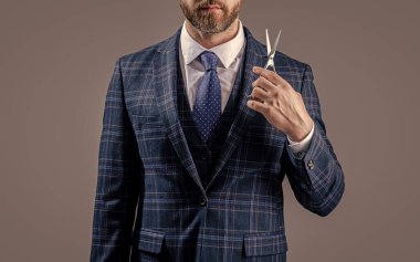 barber man with scissors. man with scissors in barber studio. photo of bearded man with barber scissors. barber man hold scissors isolated on grey background.