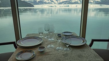 Lokanta masası manzaralı buzul körfezi manzarasının panoramik penceresinin iç tarafında. Doğal parktaki boş dağ buzulları restoranı. Hubbard Buzul Restoranı. Seyahat yeri, insan yok..