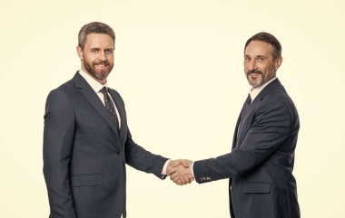 Stüdyoda iş yapan gülümseyen iş adamları. İş adamları el sıkışma ile ilgileniyor. İki iş adamı iş yapıyor, ortaklık. Beyaz arka planda izole edilmiş iş adamları.