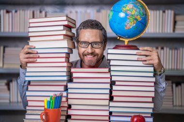 Okul kütüphanesinde eğitim. İnsan kitap kurdu bilgi edinir. Öğretmenler ve bilgi günü. Zeki öğretmen. Sınıftaki kitap kurdu adam. Kitap edebiyatı öğretmeni. İçindeki dehayı serbest bırak..