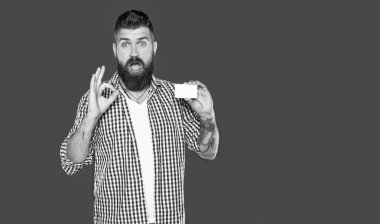 Şaşırmış sakallı adam, kopya alanı ile boş banka kartı gösteriyor.