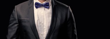 Smokinli adamın resmi papyonlu hali. Resmi takım elbiseli smokinli adamın fotoğrafı. Siyah arka planda izole edilmiş resmi smokinli adam. Resmi giyinme stüdyosundaki smokin giyen adam..