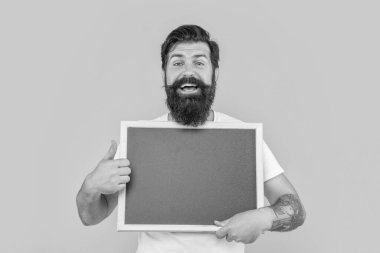 Mutlu adam stüdyoda reklam veriyor. Bir adamın fotoğrafı karatahtaya reklam veriyor. Sakallı adam sarı üzerine izole edilmiş bir ilan veriyor. Adam arka planda fotokopi alanı ile reklam sunar.