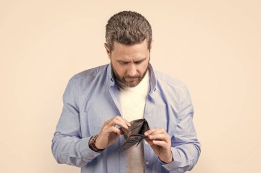 Elinde cüzdanı olan zavallı bir adam. Cüzdanı olan zavallı adamın fotoğrafı. Cüzdanı olan zavallı adam stüdyo arka planında izole edilmiş. Stüdyoda cüzdanı olan zavallı adam..