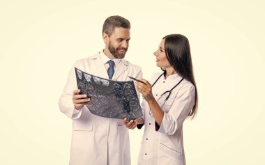 İki tıp uzmanı MRI taramalarını tartışıyor. Stüdyodaki doktor nörolog MRI. Modern bir hastanenin MRI veya tomografi odasında doktor onkolojisi. Doktor MR resmini inceler. Nörolog beyin teşhisi koydu.