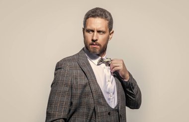Smokinli adamın yüzü gri arka planda izole edilmiş. Stüdyodaki smokinli adam. Smokin giyen adamın fotoğrafı. Erkekler smokin giyer..