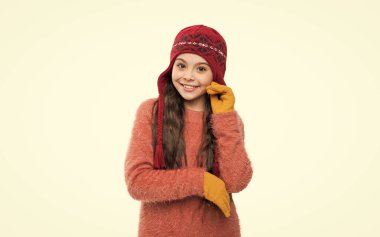 Genç kız model şapkalı gülümsüyor. Sıcak şapkalı genç kız beyaz arka planda izole edilmiş. Genç kız stüdyoda süveter ve kalın bir şapka giyer. Genç kızlar için kış modası. kalın şapka örgü.