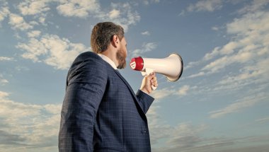 İş adamı gökyüzü arkaplanında hoparlörden anons yaptı.