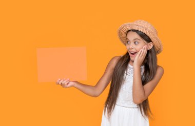 Sarı arka planda turuncu kağıtta fotokopi alanı olan şaşırtıcı bir genç çocuk..