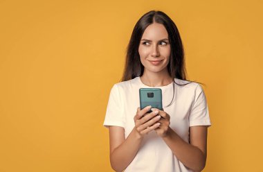 Cep telefonu stüdyosundan mesaj atan bir kadın. Akıllı telefonda cep telefonu uygulaması kullanan bir mesajcı kadın. Kadının mobil iletişimi. Cep telefonuyla sohbet ediyorlar. Telefonu olan kadın, kopyalama alanı.