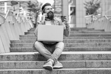 Cep telefonuyla konuşan, kahve içen mutlu bir adam. Gülümseyen adam cep telefonuyla konuşuyor. Merdivenlerde dinleniyor. Mobil iletişim. Cep telefonundan arıyorlar. Telefon görüşmesi.