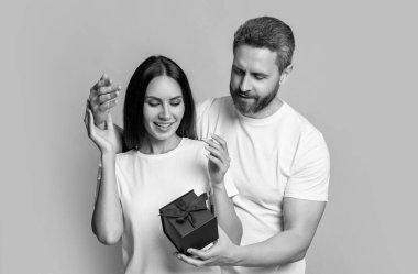 Sürpriz mavi hediye kutusu olan tatil çifti. Tatil hediyesi olan bir çiftin fotoğrafı. Kadınlar Günü 'nde. Sarı arka planda yaşayan sürpriz çift. Stüdyoda sürpriz bir çift var..