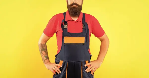 stock image cropped man technician in work clothes on yellow background.