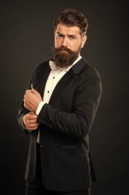 Smokinli sakallı iş adamı siyah arka planda, takım elbiseli..