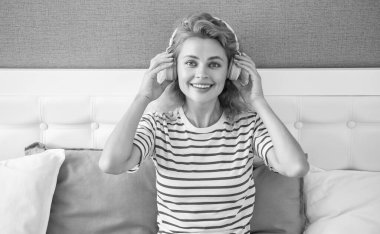 Yatakta müzik dinleyen mutlu bir kız. Kadın evde boş vakit geçirmekten zevk alıyor. Boş zaman müziği..