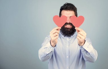 Yüreğiyle görebiliyor. Hippi gözlerini küçük kalplerle kapatıyor. Kırmızı kalp tutan sakallı adam. Aşk kartları olan seksi bir sevgililer günü erkeği. Sevgililer günün kutlu olsun. Aşkını ifade ediyor, kopyalama alanı.