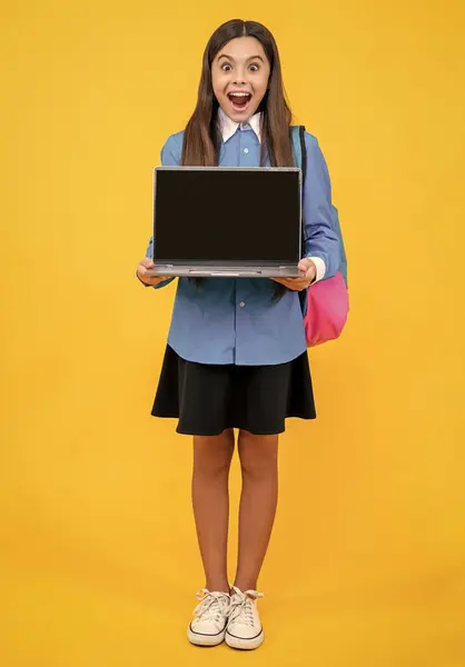 stock image amazed school girl presenting estudy education. photo of school girl presenting estudy education. school girl presenting estudy education isolated on yellow. school girl presenting estudy education