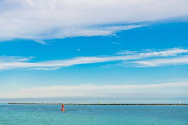 Denizde şamandıra. Gemiler için deniz navigasyonu iç geçiriyor. Kırmızı şamandıralı deniz pelerini. Deniz suyunda yüzen şamandıra. Deniz manzaralı ufuk. Denizcilik yön bulma işareti.