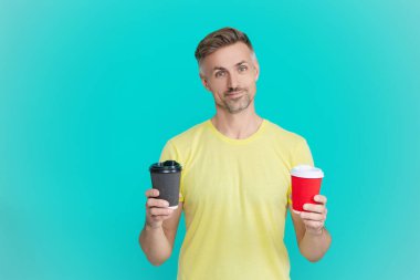 Olgun bir adam mavi üzerine kafeinsiz kahve fincanı seçer. Sabah kahvesi vakti. Yaşam tarzı konsepti. Kafeinsiz içiyorum. Çay içen adam. Sıcak bir sabah, rahatla. Kahveci adamla kahve molası. Reklam..